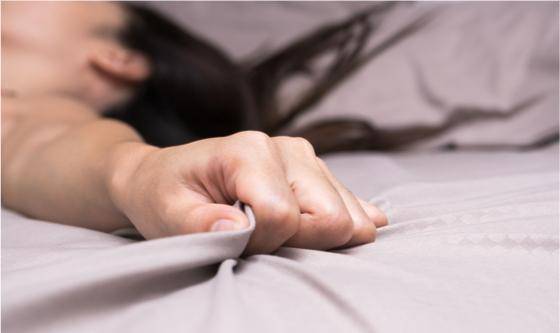 femme saisissant son lit pendant un orgasme