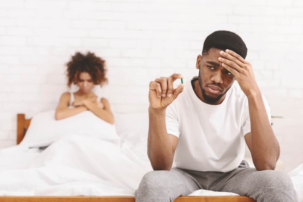  Un Africain stressé prenant une pilule de puissance avant de coucher avec sa petite amie
